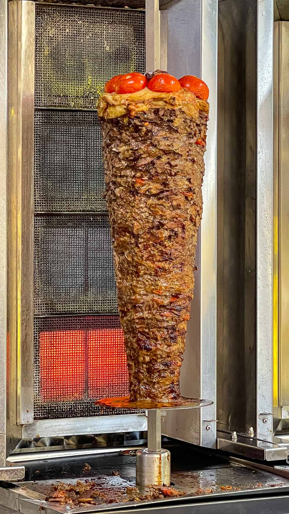 Lamb doner being cooked on a vertical spit.