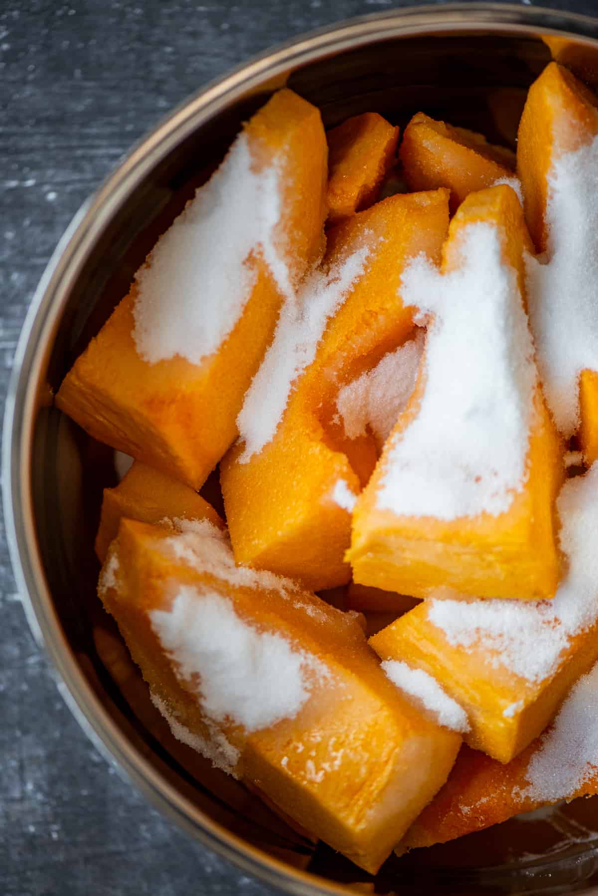 Pumpkin wedges topped with granulated sugar in a pot.