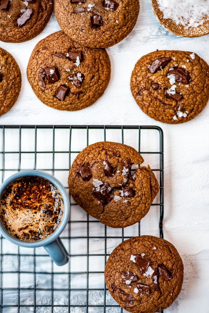 Brown butter coffee cookies on a wire rack accompanied by a cup of coffee
