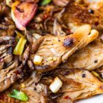 Fried oyster mushrooms in butter with spices, garlic and green onions.