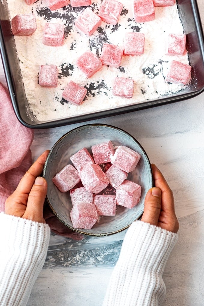 Turkish Delight Candy coated with cornstarch and powdered sugar in a bowl and in a pan