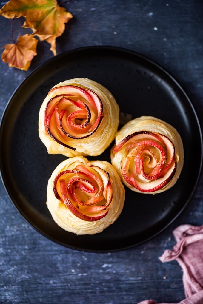 Apple roses made with a puff pastry sheet on a black plate