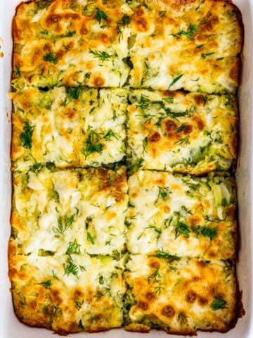 Cheesy cabbage casserole with fresh dill in a baking pan.