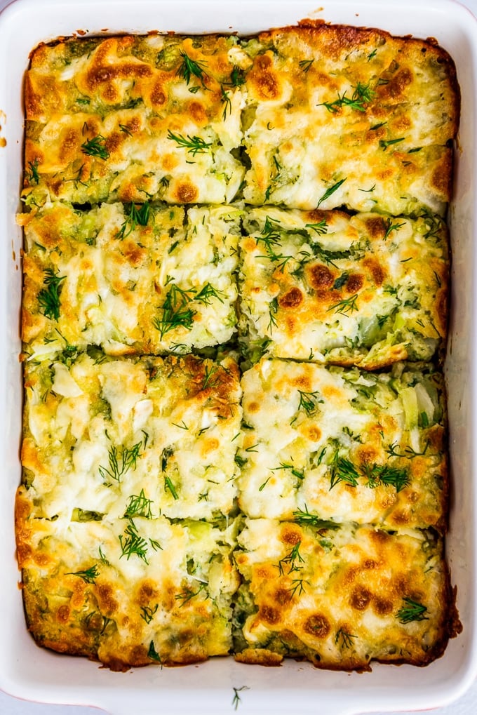 cheesy cabbage casserole with fresh dill in a baking pan