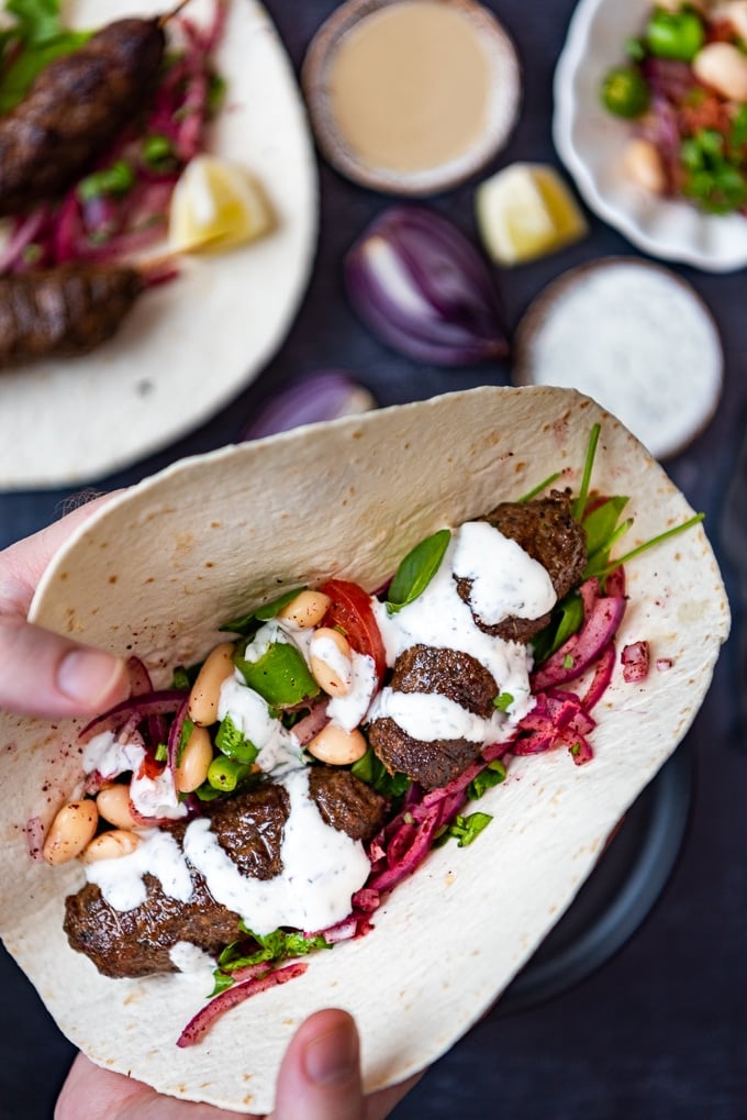 Lamb and beef kofta skewers in a wrap with yogurt sauce.