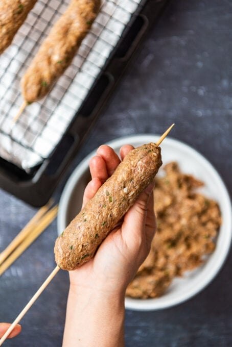 moulding kofta kebab mixture on wooden skewers