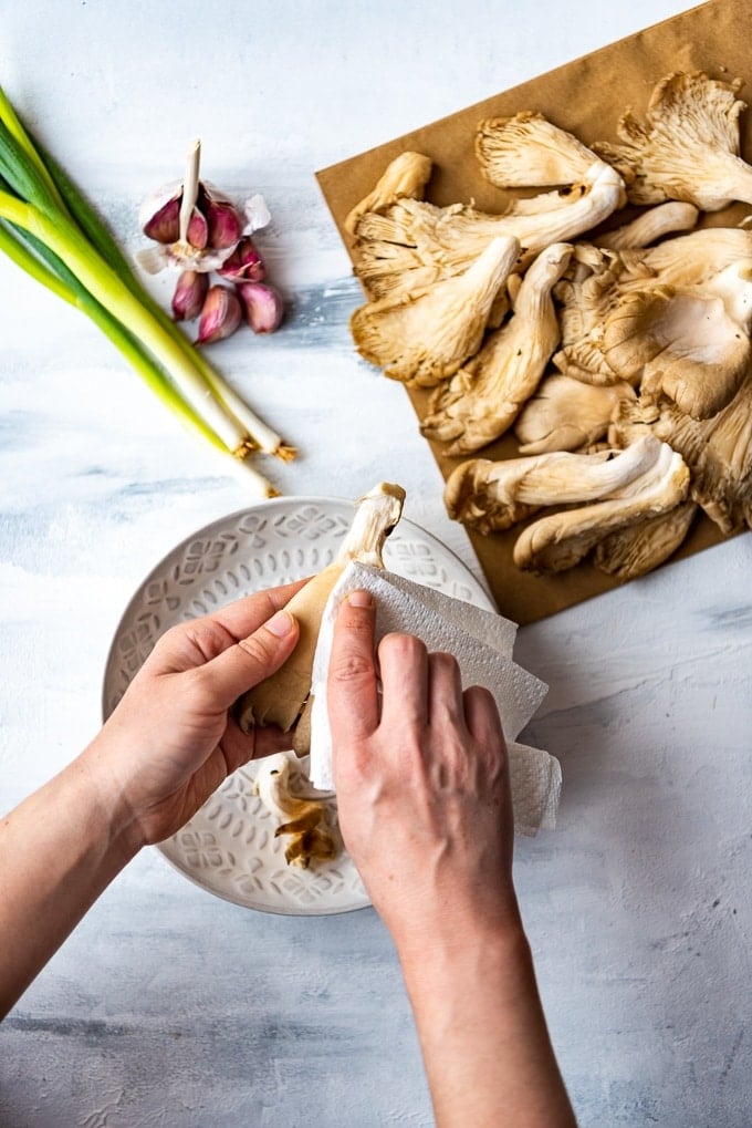 showing how to prepare oyster mushrooms with a paper kitchen towel