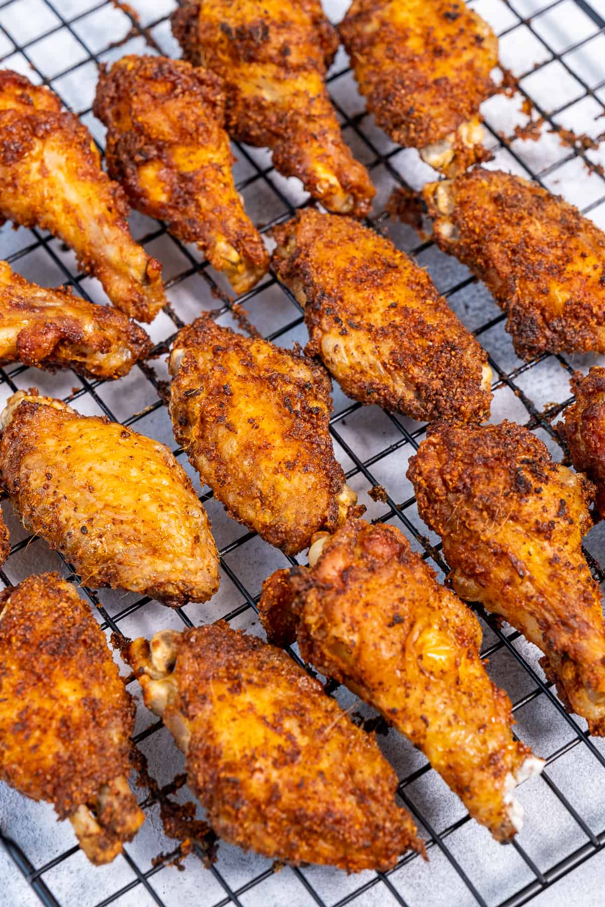 Baked chicken wings on a baking rack.