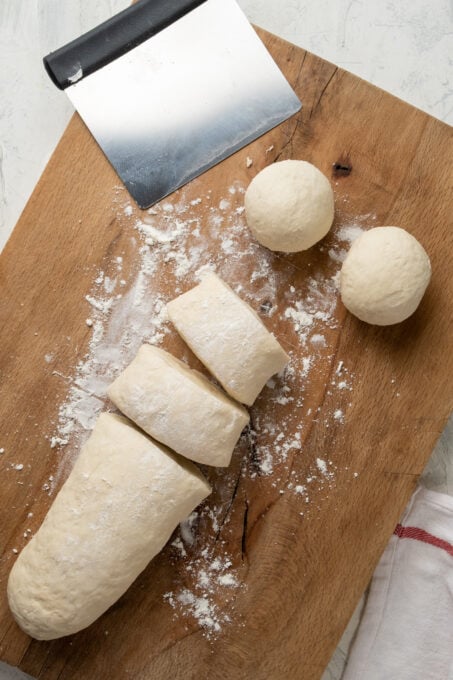 Dough cut into pieces on a wooden board.