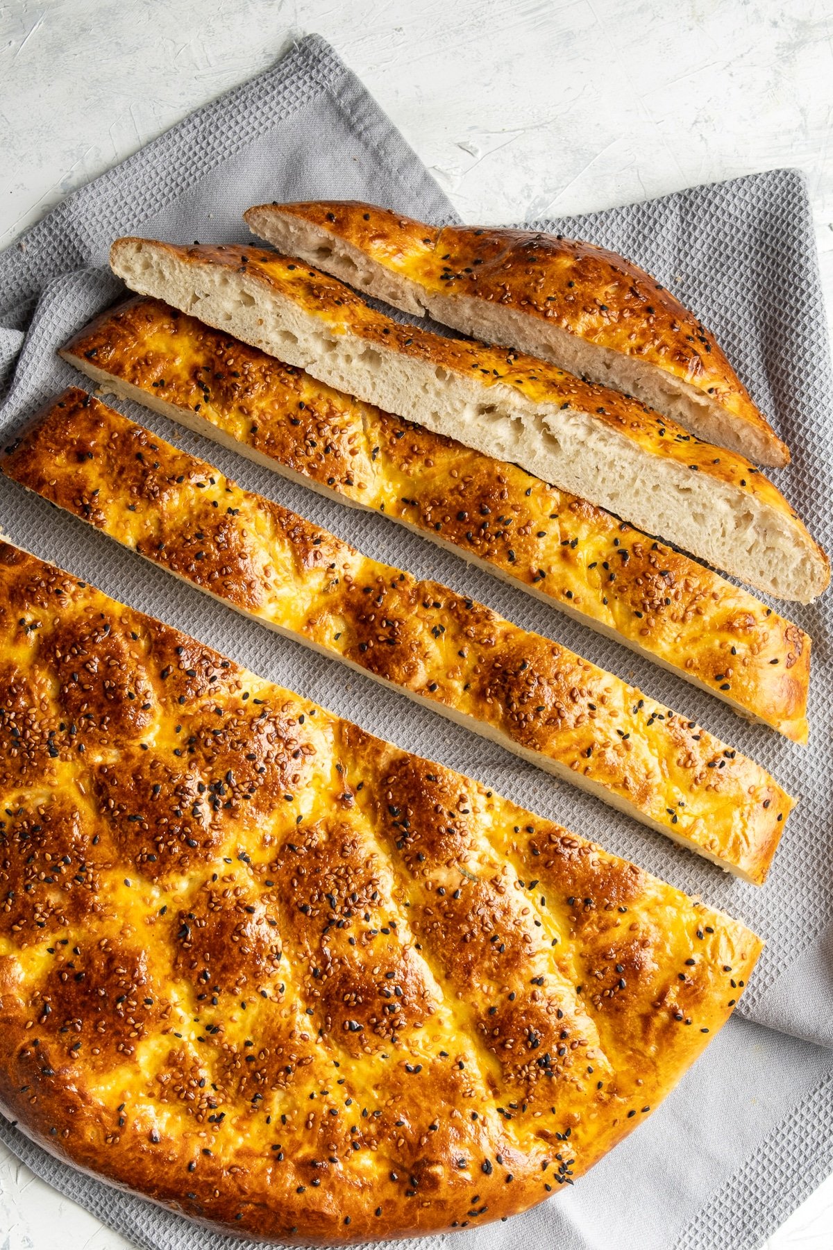 Ramadan pide bread half sliced on a light background.