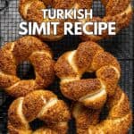Simits on a cooling rack on a dark background.