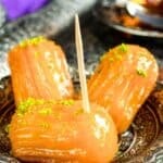 Turkish tulumba dessert made of fried dough soaked in syrup and topped with pistachio.