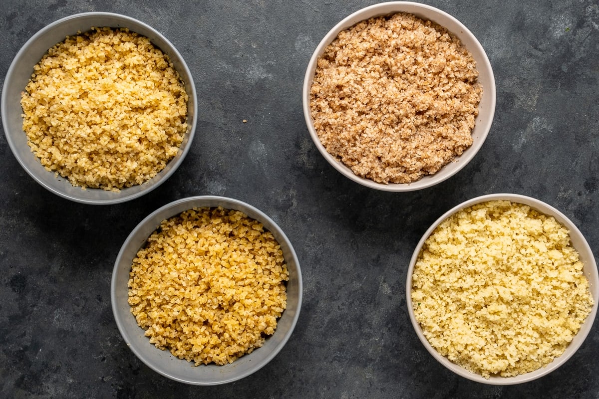 Two bowls of fine bulgur and two bowls of medium bulgur on a dark background.