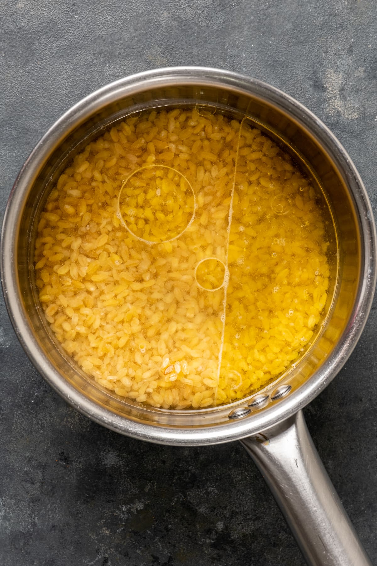 Very coarse bulgur in a saucepan with water and oil.