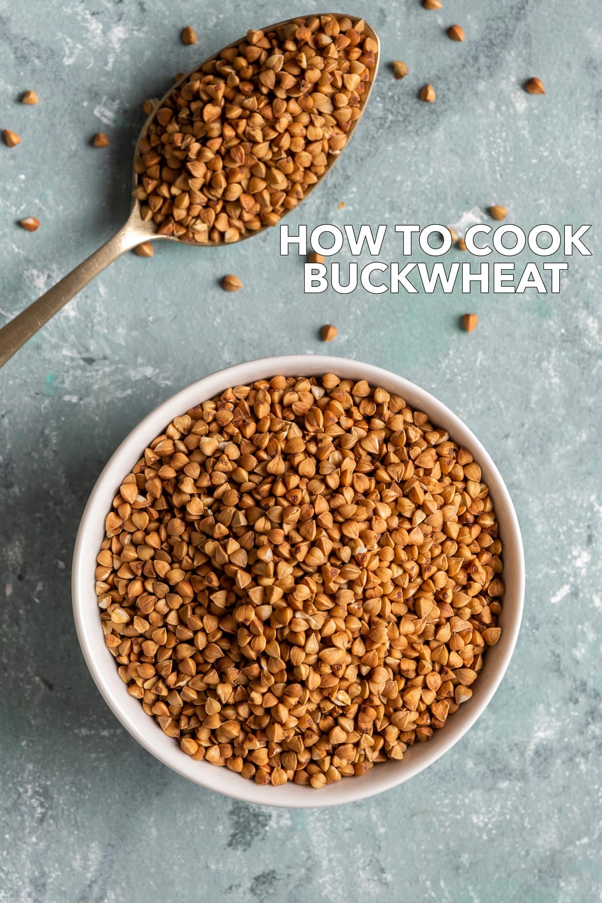 Roasted buckwheat in a bowl and a spoon full of buckwheat on the side on a light background.