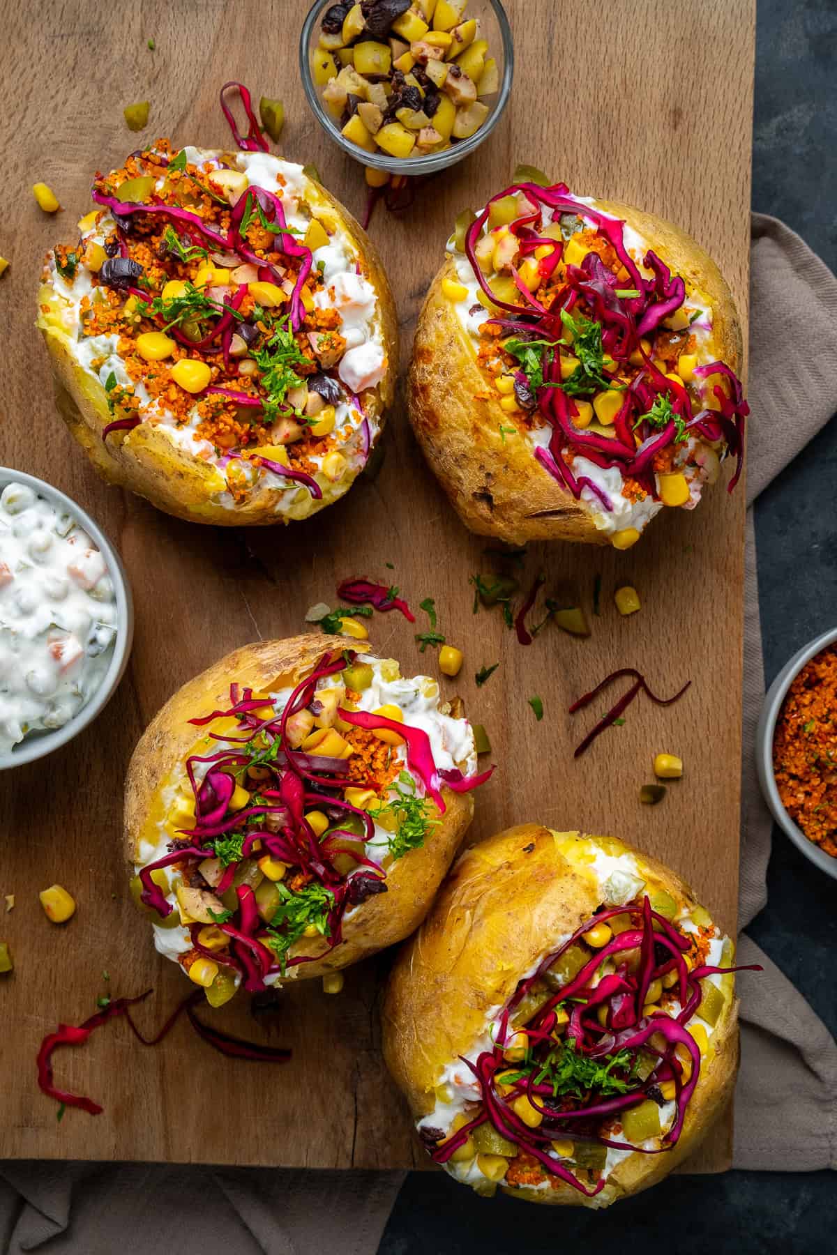 Turkish stuffed baked potatoes on a wooden serving board.