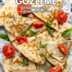 Gözleme sliced in triangles served with halved cherry tomatoes and fresh mint leaves.
