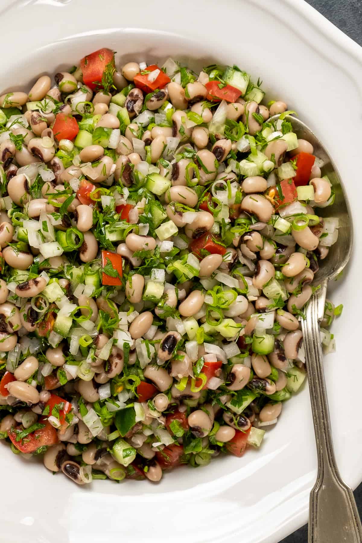 Black-eyed bean salad in a white bowl from top view.