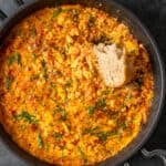 Menemen in a pan and a piece of bread in it.