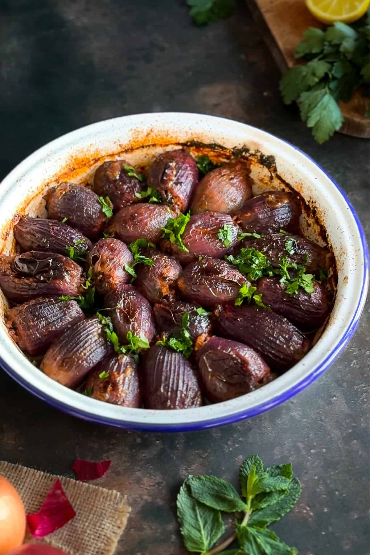 A dish of Sogan Dolmasi (Turkish Stuffed Onions), freshly baked and garnished with chopped parsley.