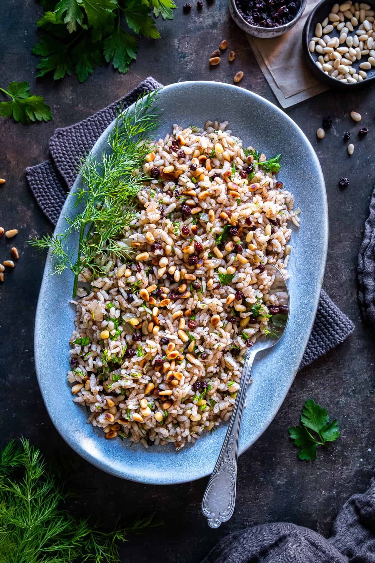 Finished Turkish iç pilav served on a plate, made with rice, pine nuts, currants, fresh herbs, and warm spices.