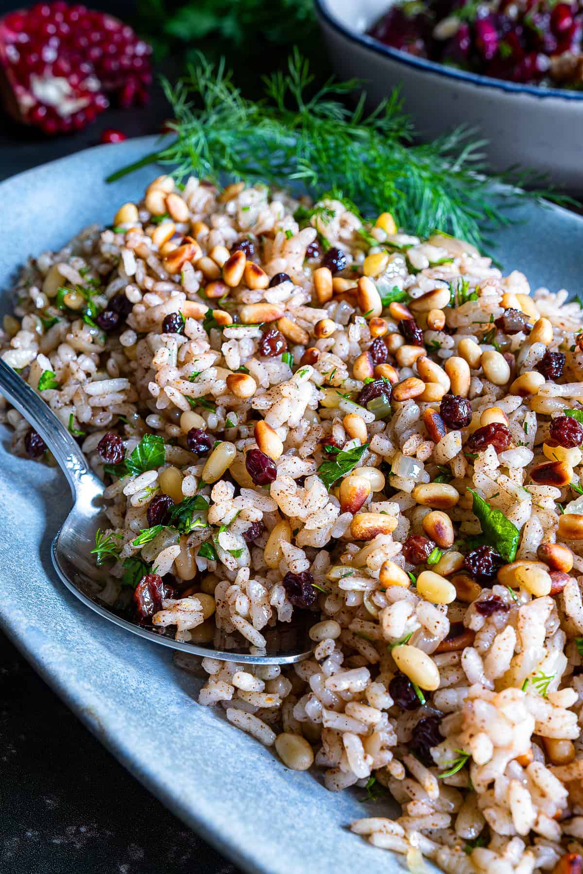 Close-up of Turkish iç pilav with rice, pine nuts, currants, and fresh herbs, ready to serve.