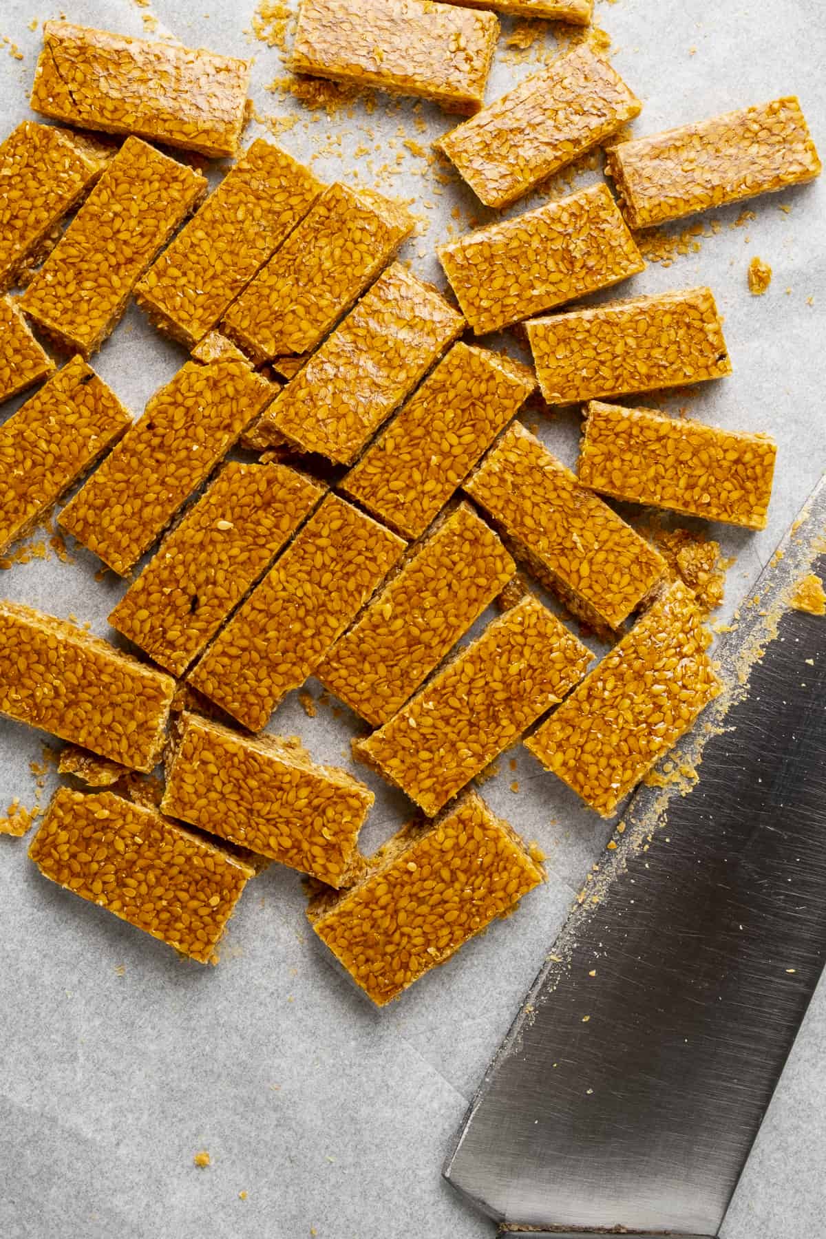 Sesame seed candies cut into small rectangles on baking paper.