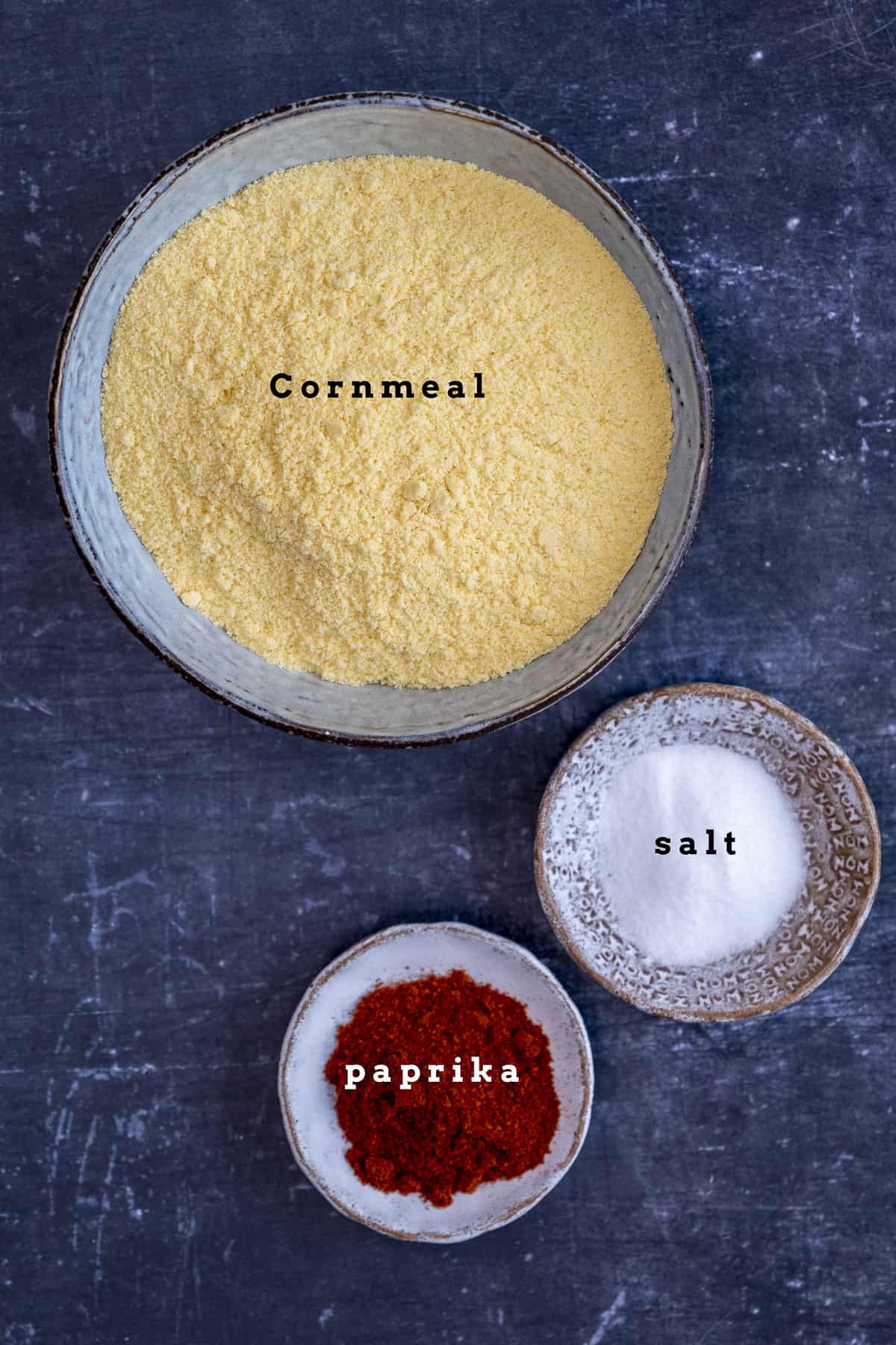 Cornmeal, paprika and salt in small bowls.
