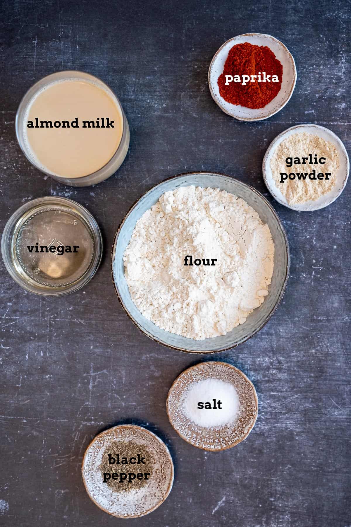 Flour, almond milk, vinegar and spices in small bowls.