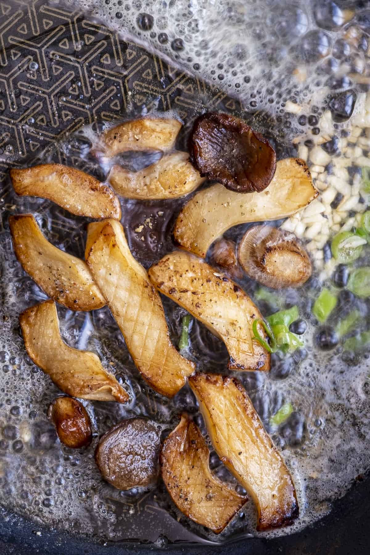 King oyster mushrooms cooked until golden in a pan.