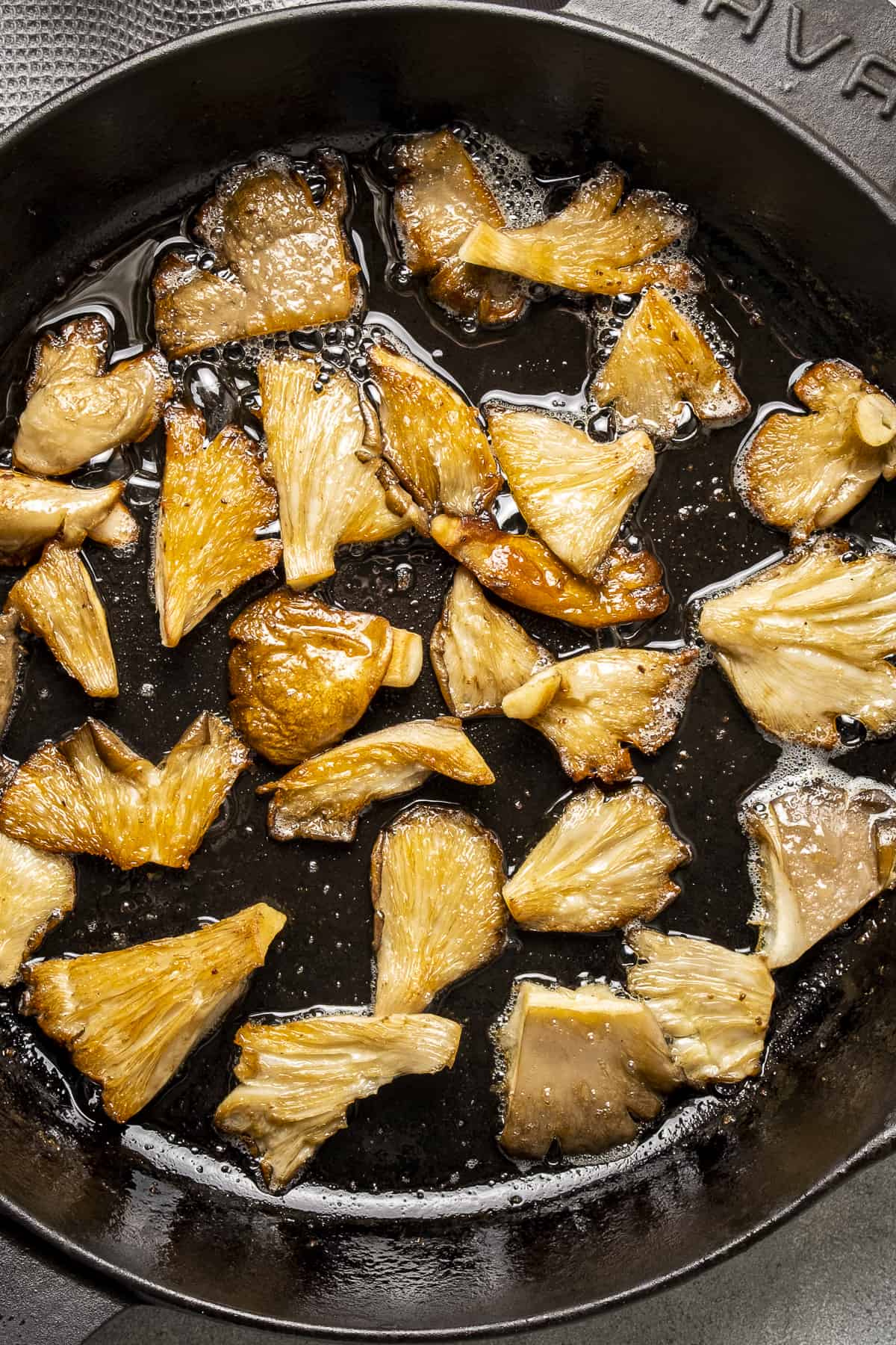 Golden oyster mushrooms cooked in a cast iron pan.