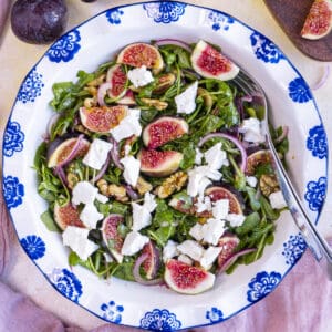 Arugula and fig salad in a white salad bowl.