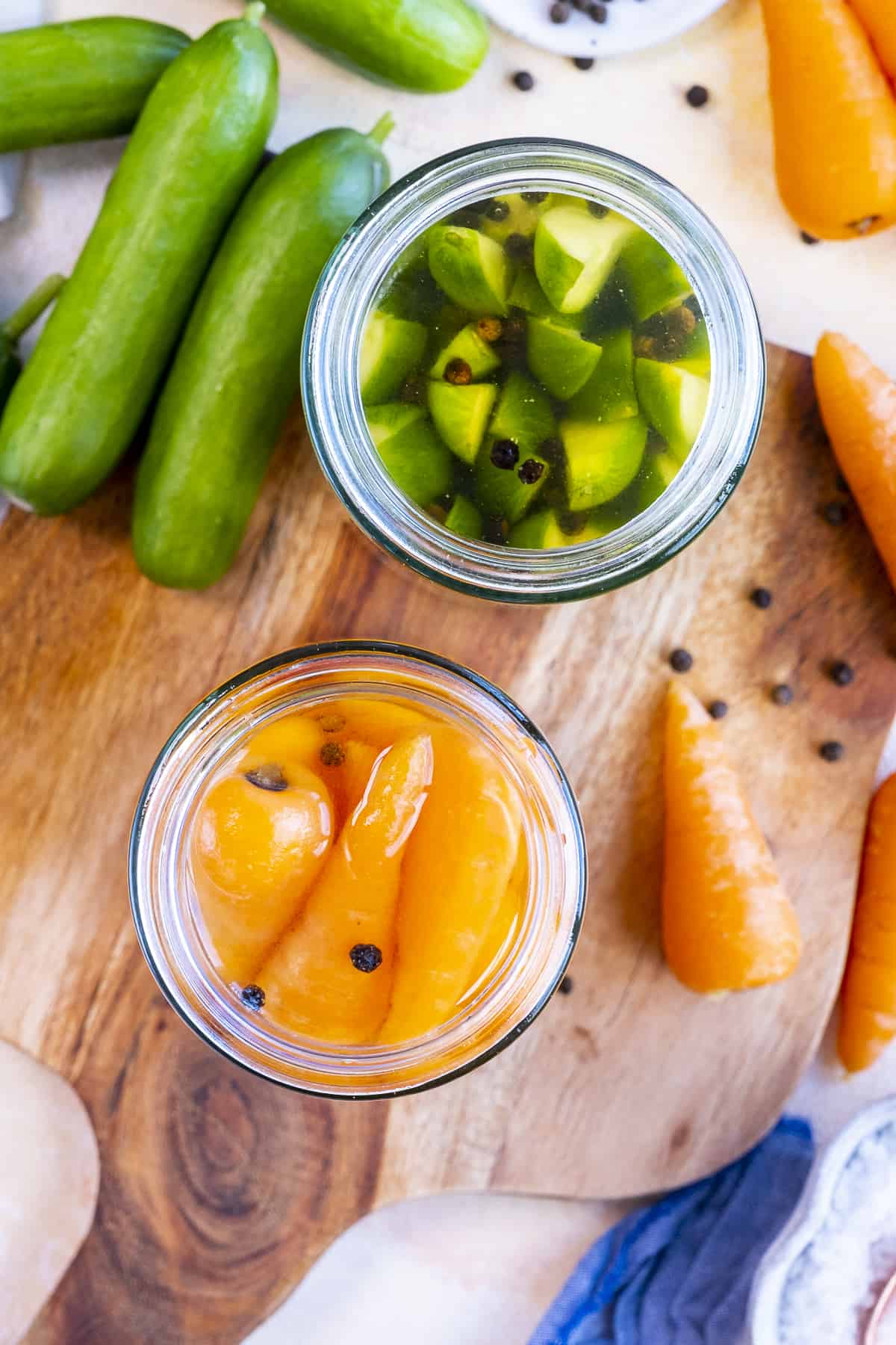 Cucumber spears and carrots in two jars.