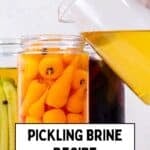 Pouring pickling brine into a jar filled with carrots for homemade pickles.