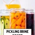 Pouring pickling brine into jars filled with cucumbers and carrots for homemade pickles.