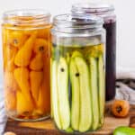 Pickled cucumbers, carrots and beets in jars.