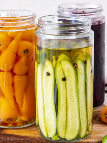 Pickled cucumbers, carrots and beets in jars.