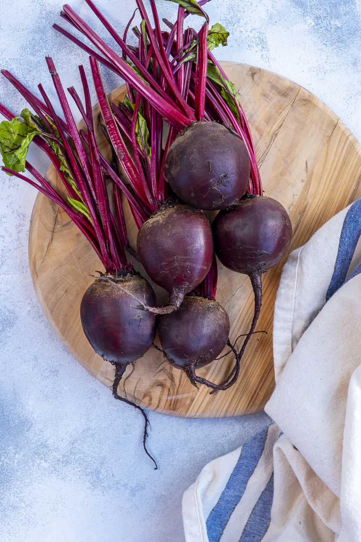 Raw beets on a wooden board.