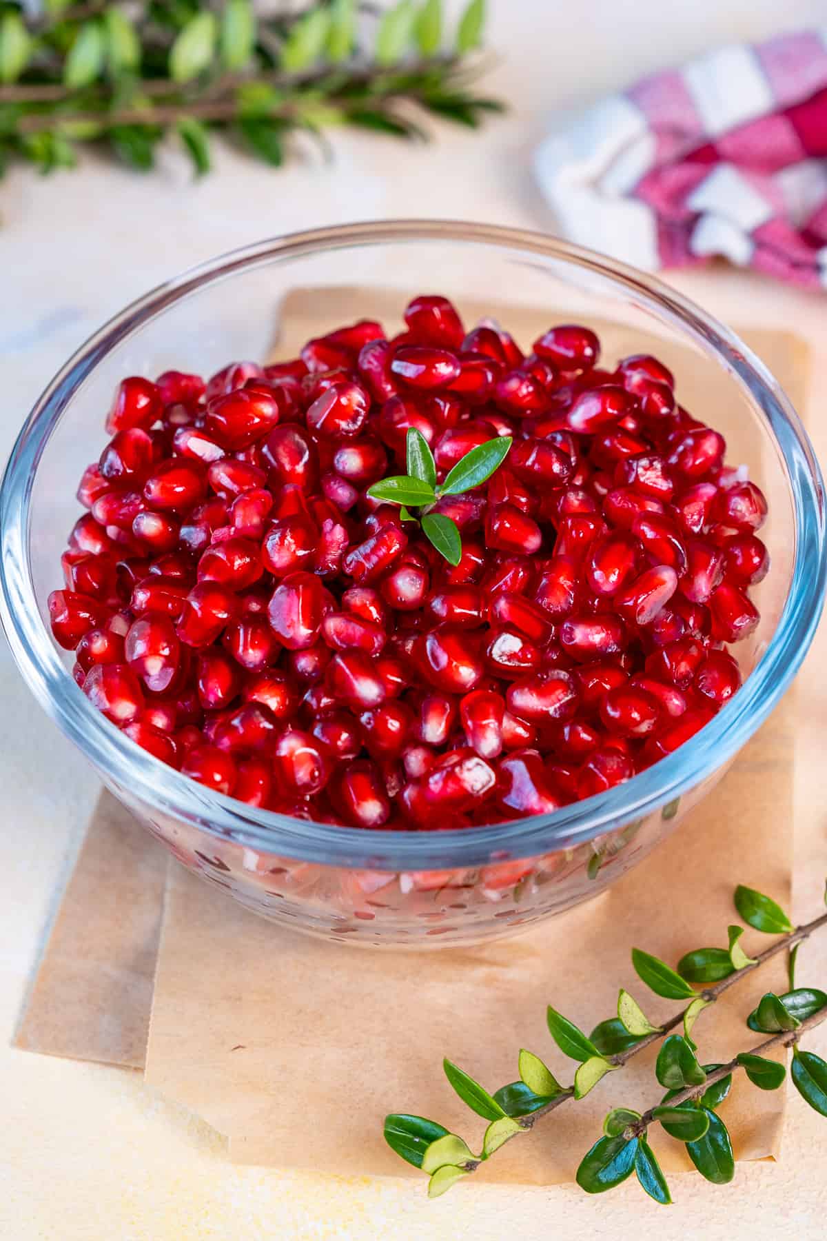 Fresh pomegranate seeds in a glass bowl.