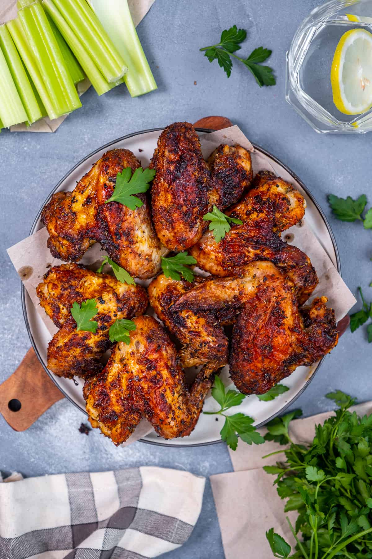 Whole chicken wings on a plate, celery sticks on the side.