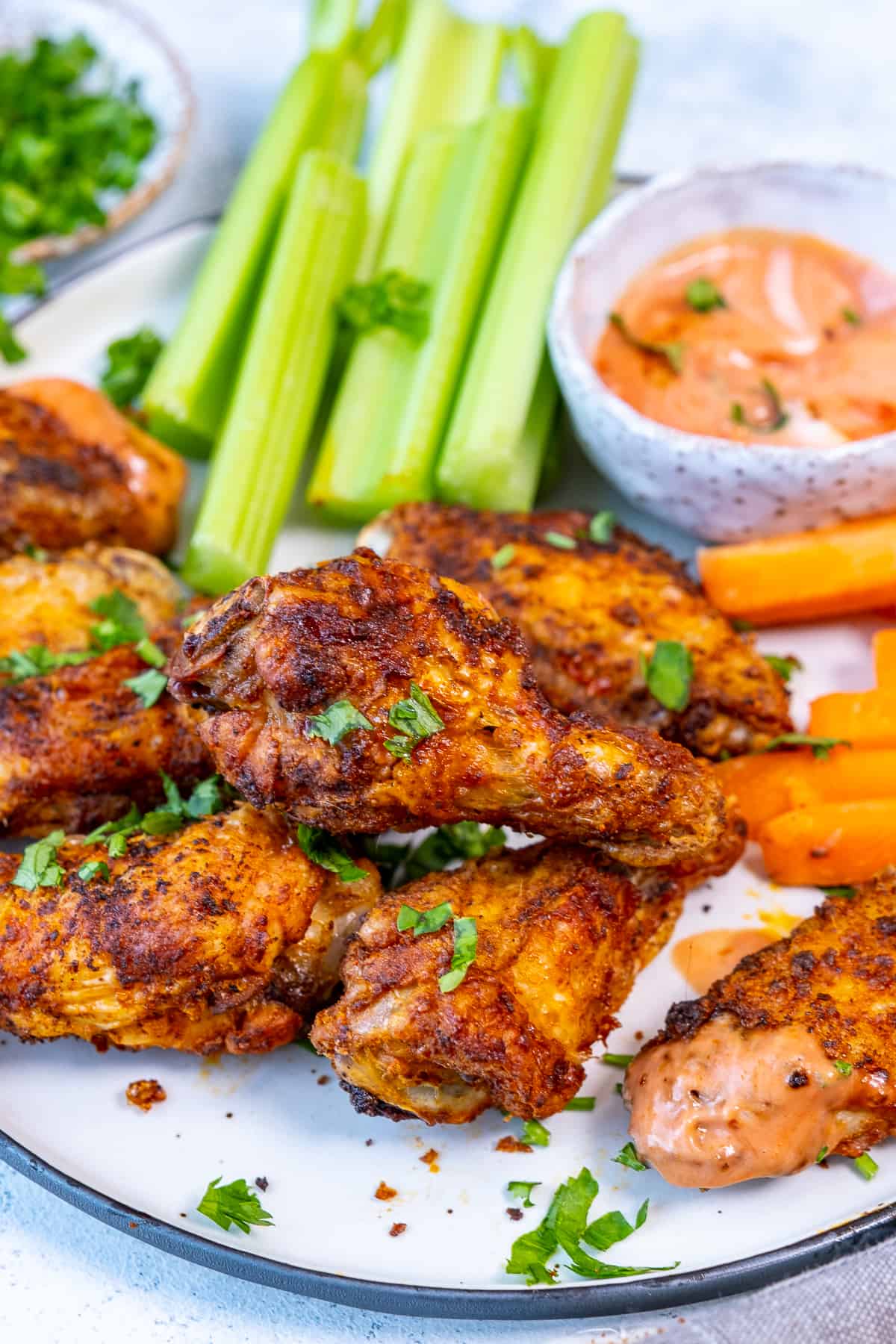 Chicken wings with celery sticks, carrot sticks and a dipping sauce.