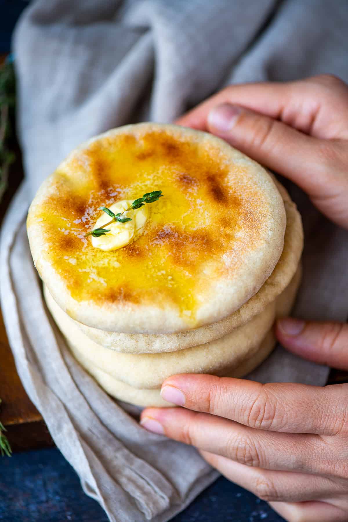 Hands holding a stack of Turkish bazlama bread.