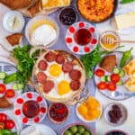 Turkish breakfast with egg dishes, pastries like borek and simit, jams, olives, cheese, vegetables and Turkish tea.