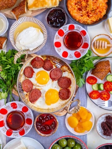 Turkish breakfast with egg dishes, pastries like borek and simit, jams, olives, cheese, vegetables and Turkish tea.