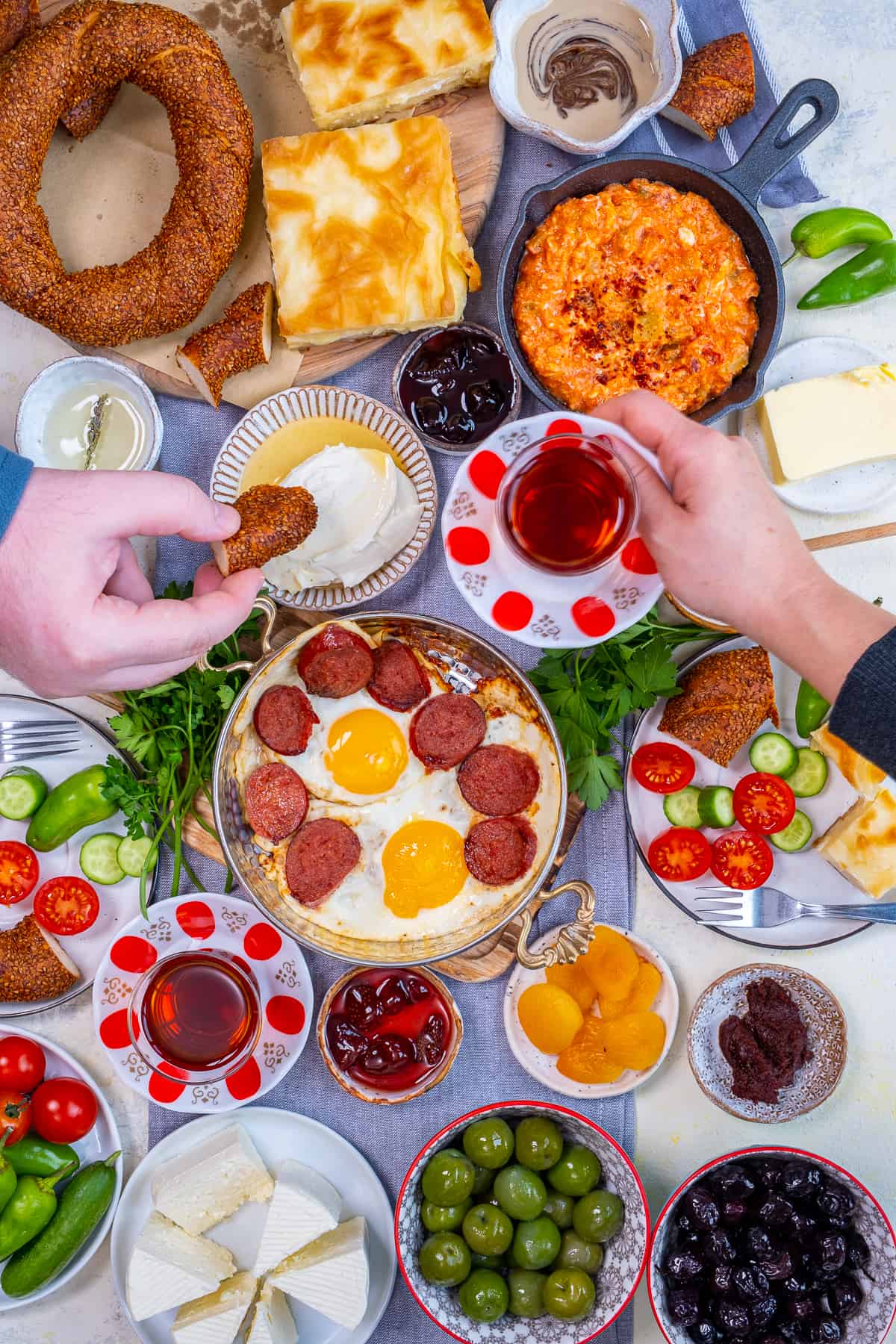 Woman and man enjoying Turkish breakfast foods and tea.