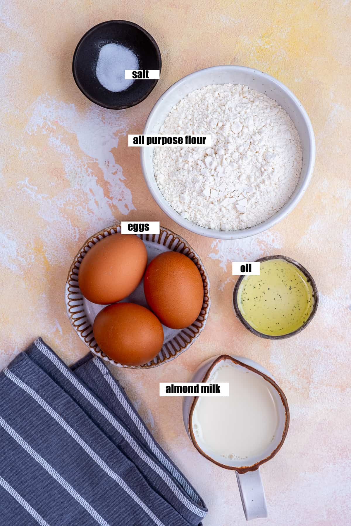 Salt, flour, eggs, oil and almond milk on a light background.