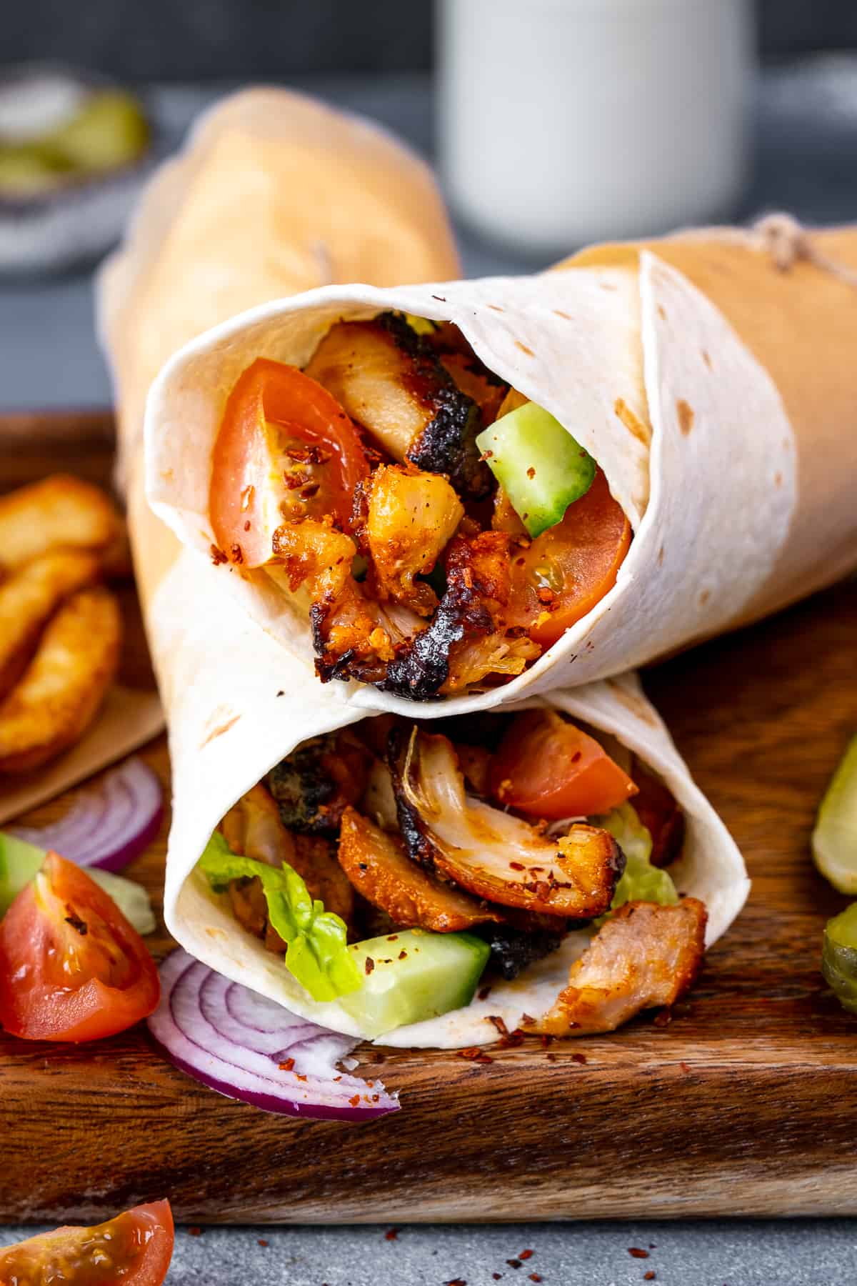 Chicken doner wraps with salad on a wooden board.