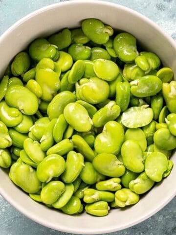 Fresh fava beans peeled and ready to cook in a bowl.