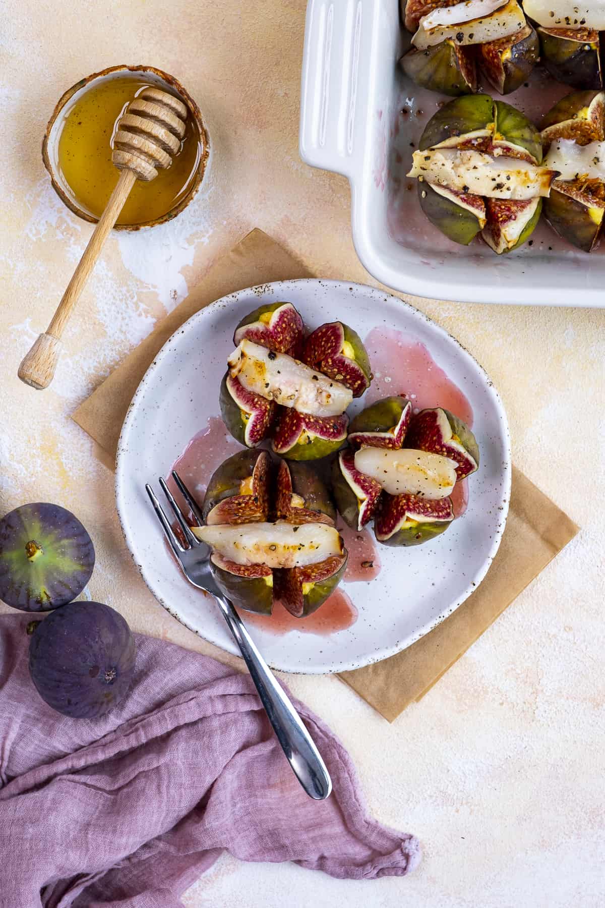 Figs stuffed with goat cheese served on a white plate.