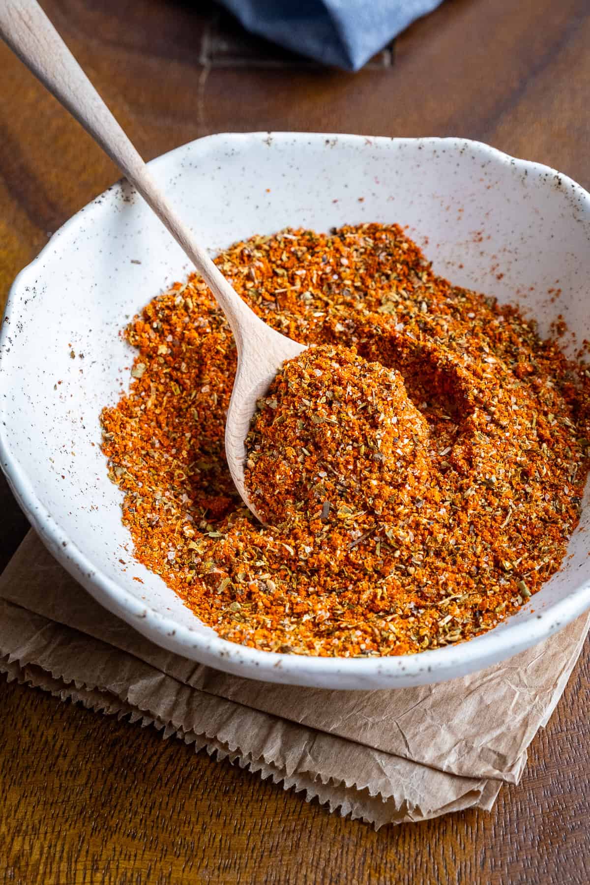 Turkish spice mix in a white bowl and a wooden spoon inside it.